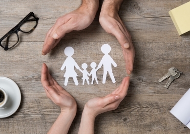 hands around paper cut outs of family